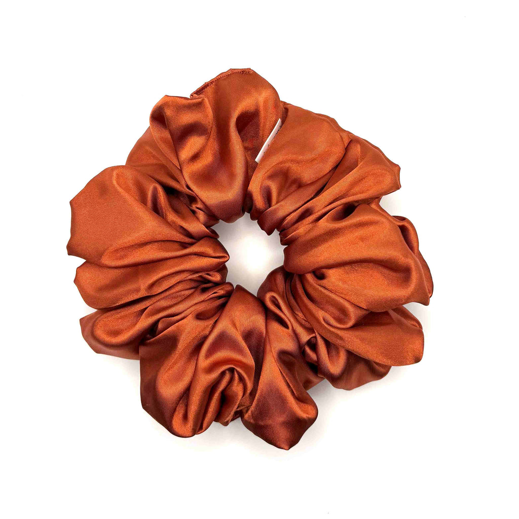Orange satin scrunchie on a white background