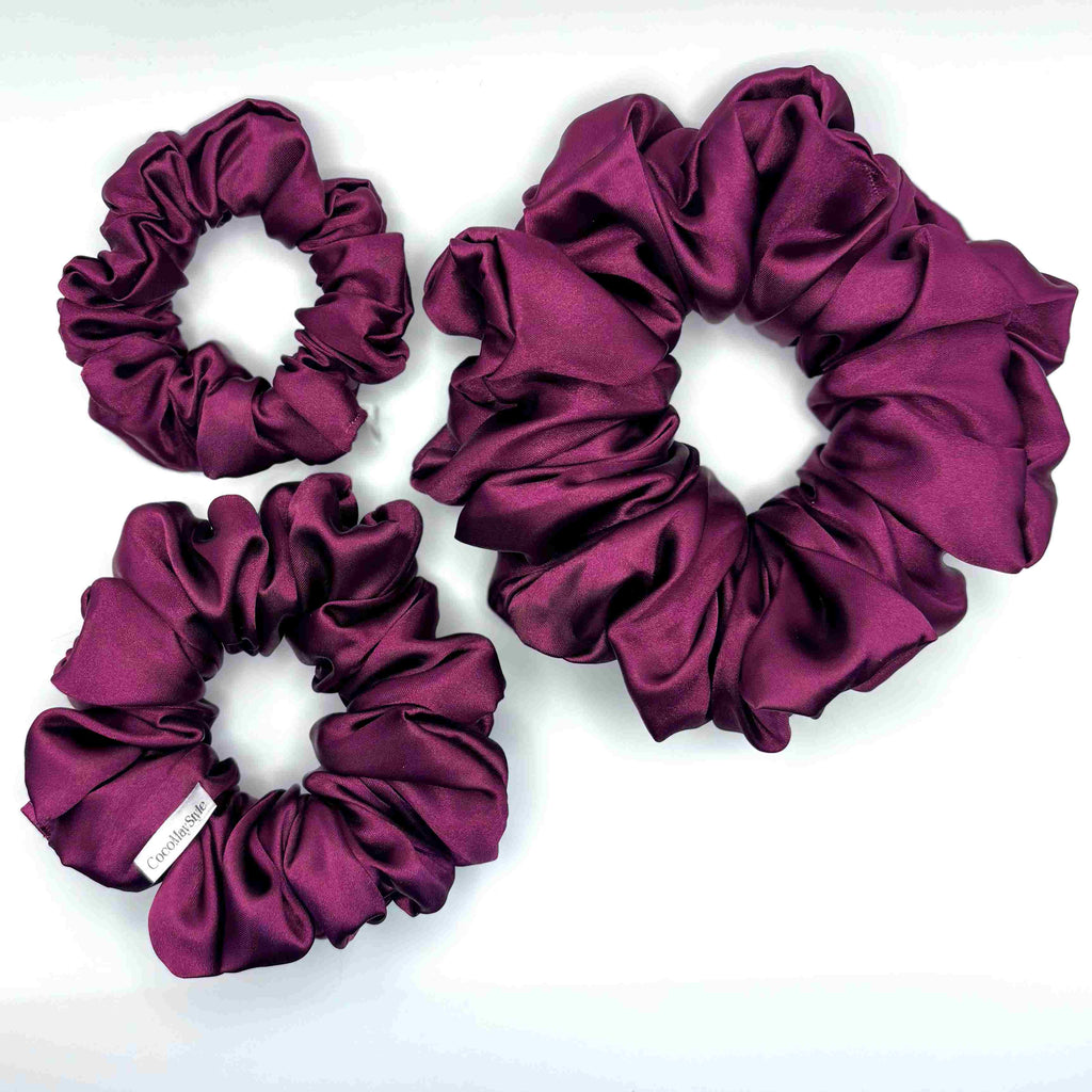 Purple satin scrunchies on a white background