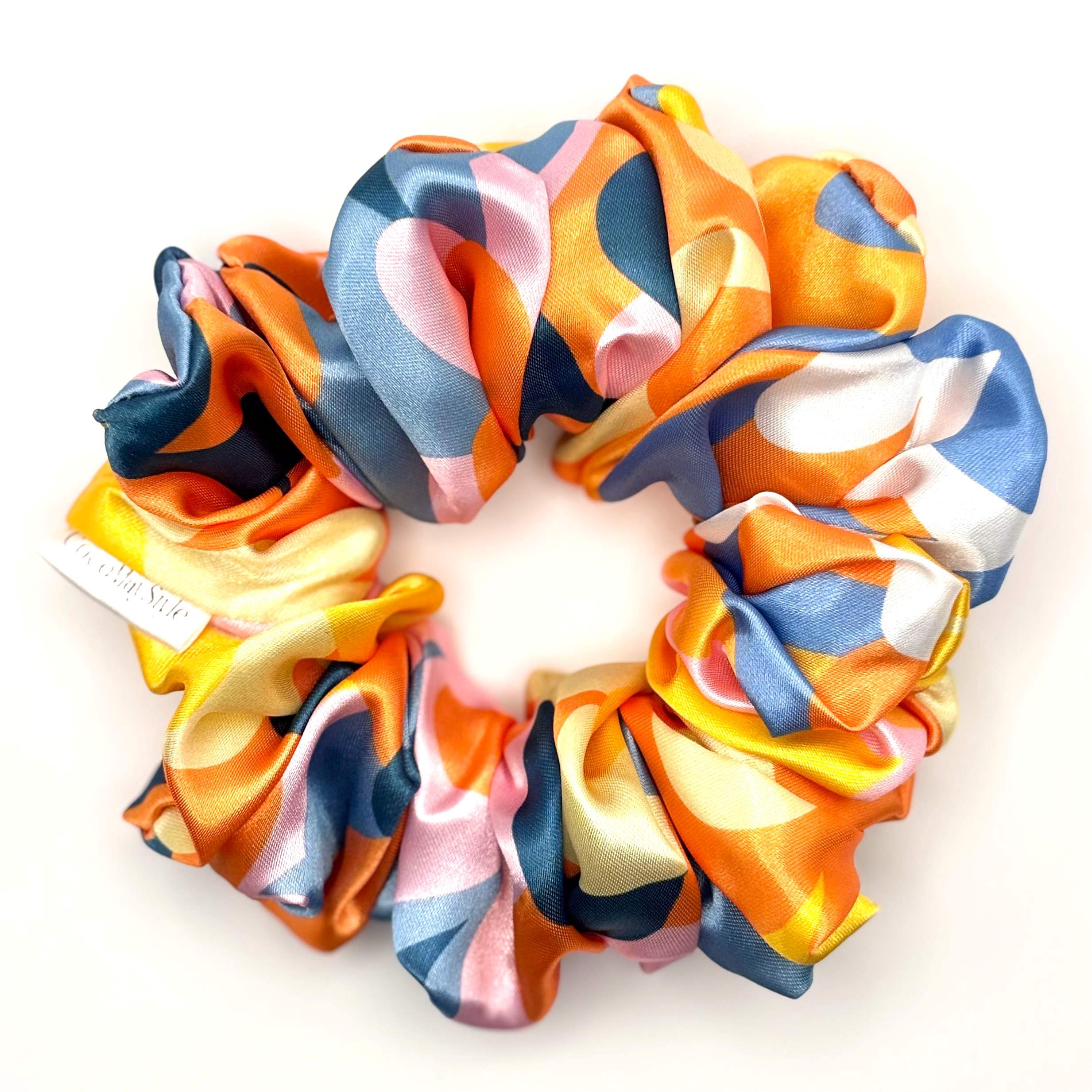 Colorful patterned satin scrunchie on a white background