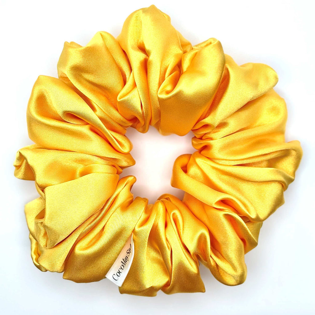 Yellow satin scrunchie on a white background
