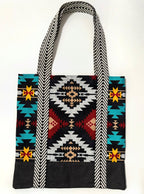 Tote bag with colorful geometric pattern, with black bottom and black and white chevron pattern bag straps