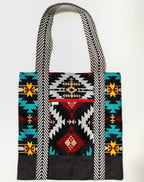 Tote bag with colorful geometric pattern, with black bottom and black and white chevron pattern bag straps