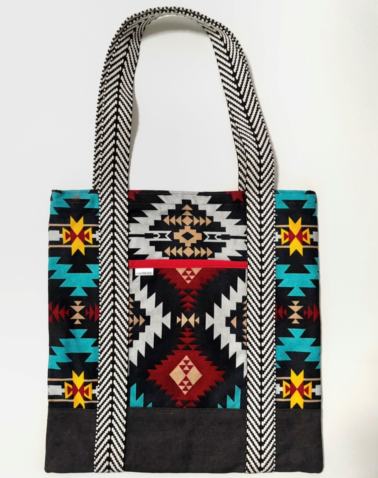 Tote bag with colorful geometric pattern, with black bottom and black and white chevron pattern bag straps