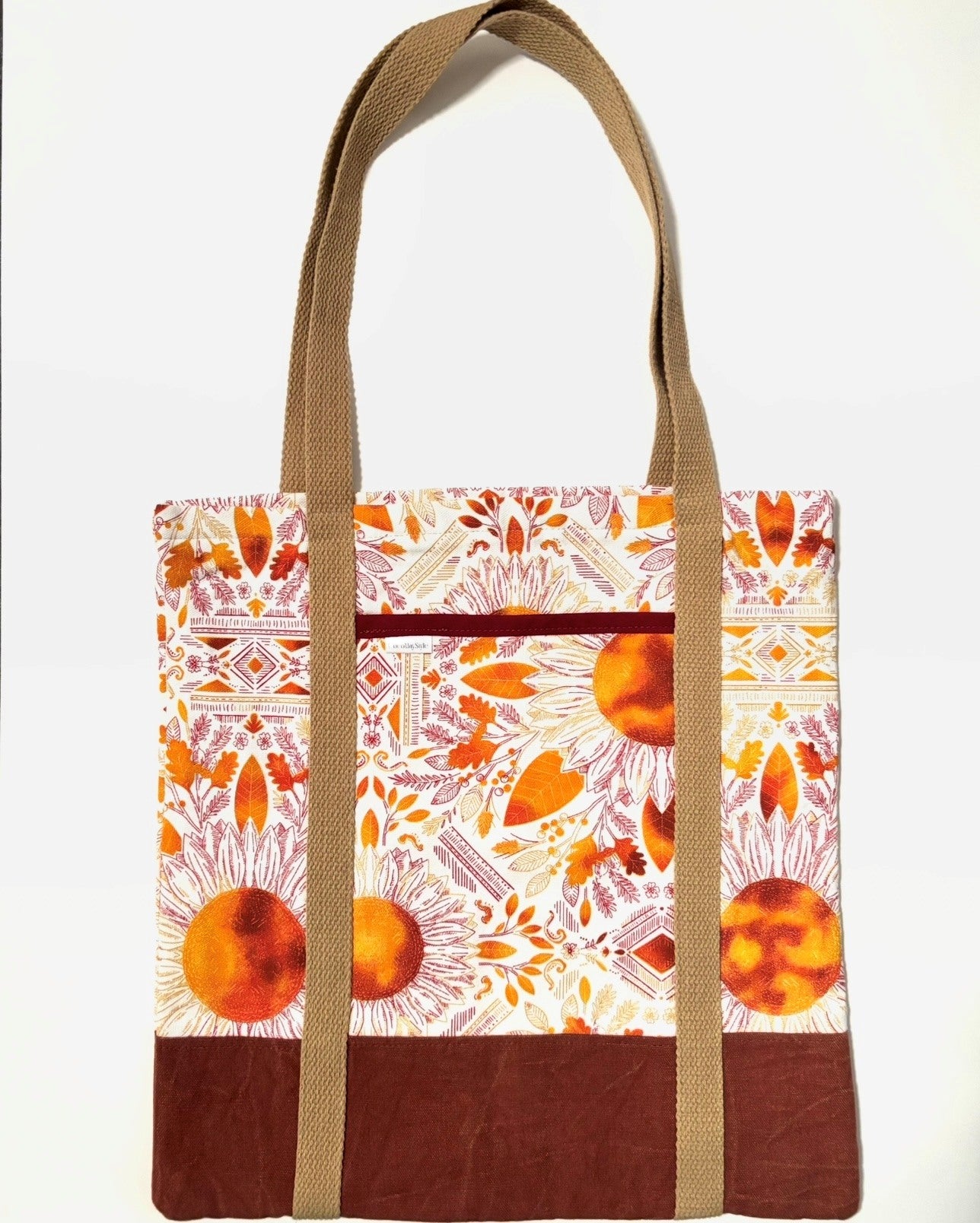 Tote bag with colorful floral pattern, with rusty brown bottom and light brown bag straps