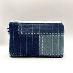 Zipper pouch with white stitching on a dark blue denim background
