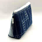 Zipper pouch with white stitching on a dark blue denim background