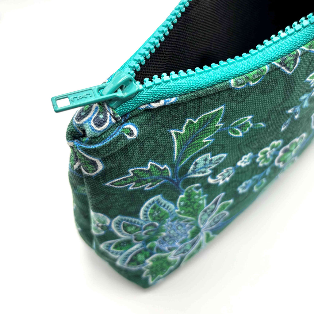 Zipper pouch with green floral pattern on a dark green background