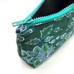Zipper pouch with green floral pattern on a dark green background