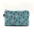 Zipper pouch with a red, white, and blue cacti and succulent pattern on a light blue background