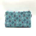 Zipper pouch with a red, white, and blue cacti and succulent pattern on a light blue background