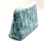 Zipper pouch with a red, white, and blue cacti and succulent pattern on a light blue background