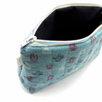 Zipper pouch with a red, white, and blue cacti and succulent pattern on a light blue background