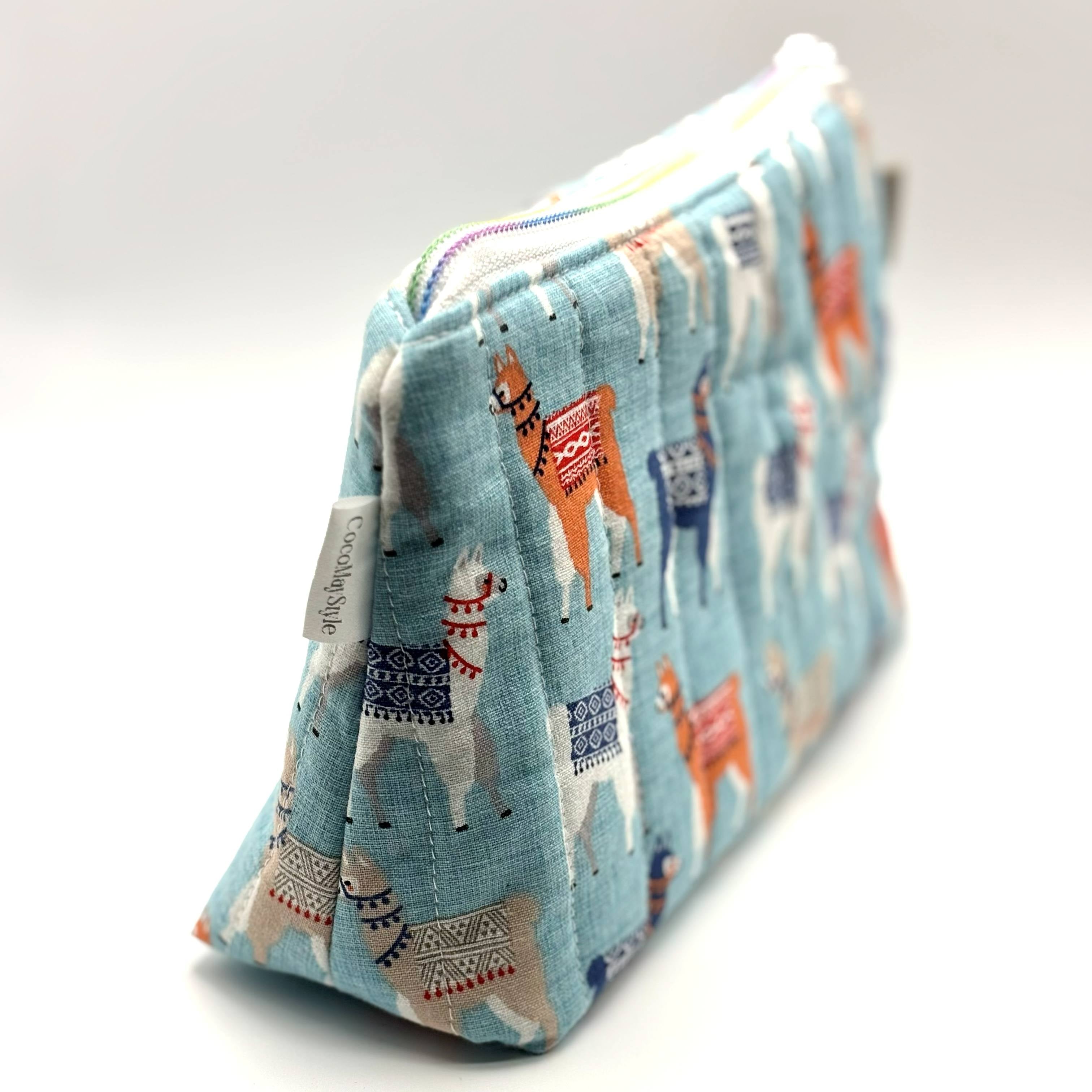 Zipper pouch with a llama pattern on a light blue background
