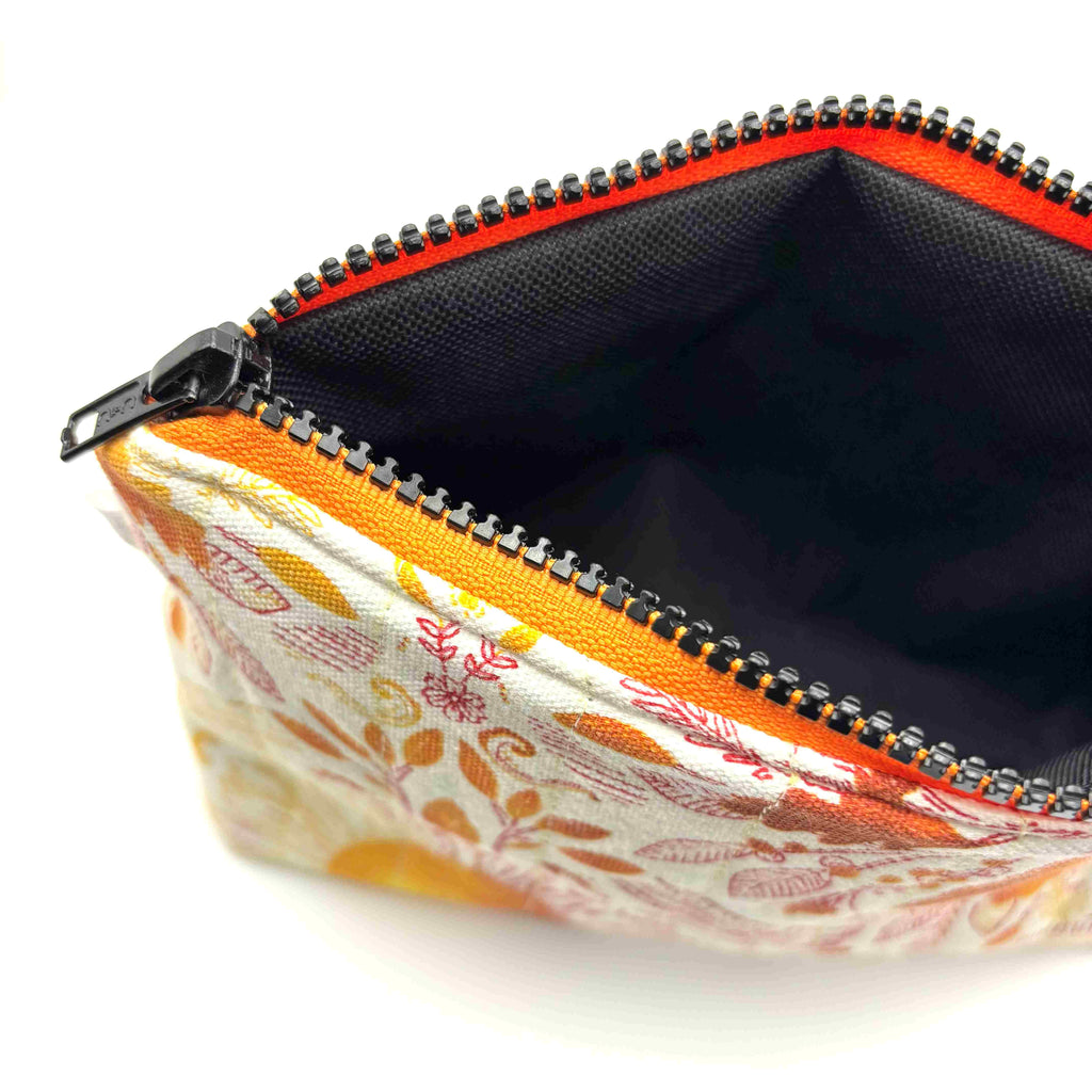 Open zipper pouch with a pink, orange, and yellow floral pattern